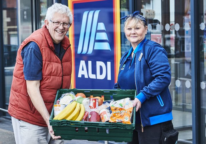 Photo of Aldi staff holding a crate of food
